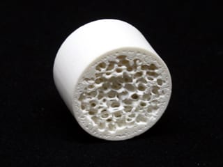 A closeup of a ceramic part with deep holes